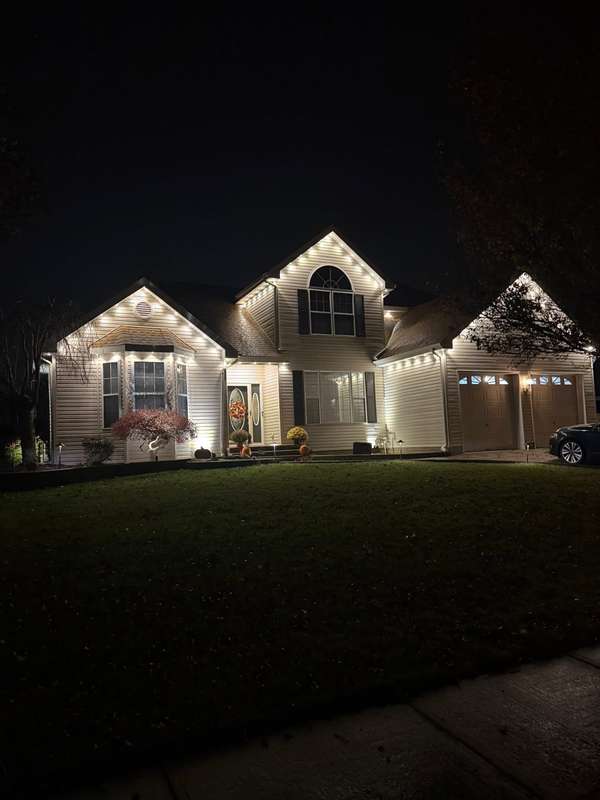 Govee permanent trim lighting in warm white along the gables and garage roofline of a two-story home at night