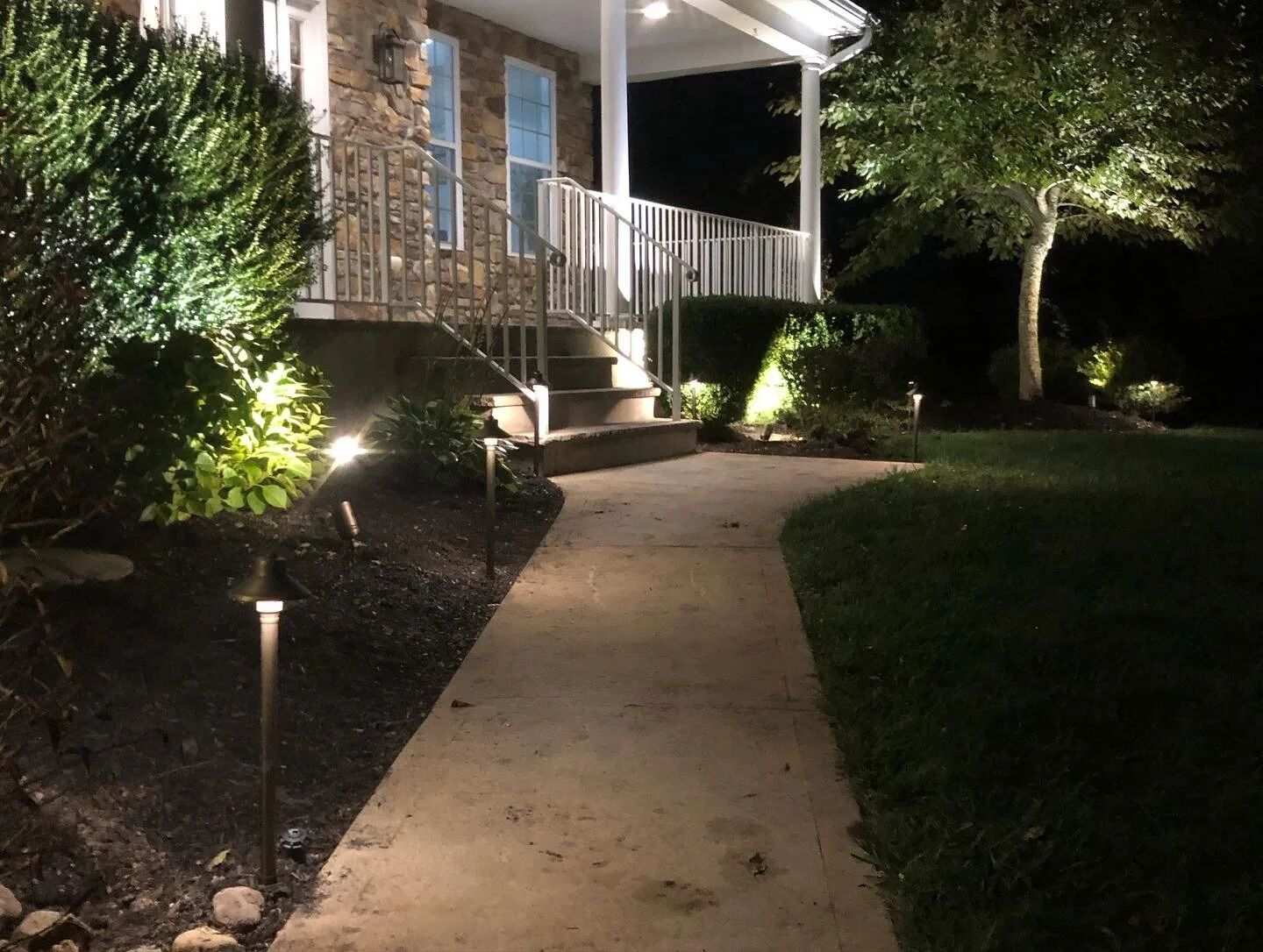 Pathway lights glowing along a walkway at night